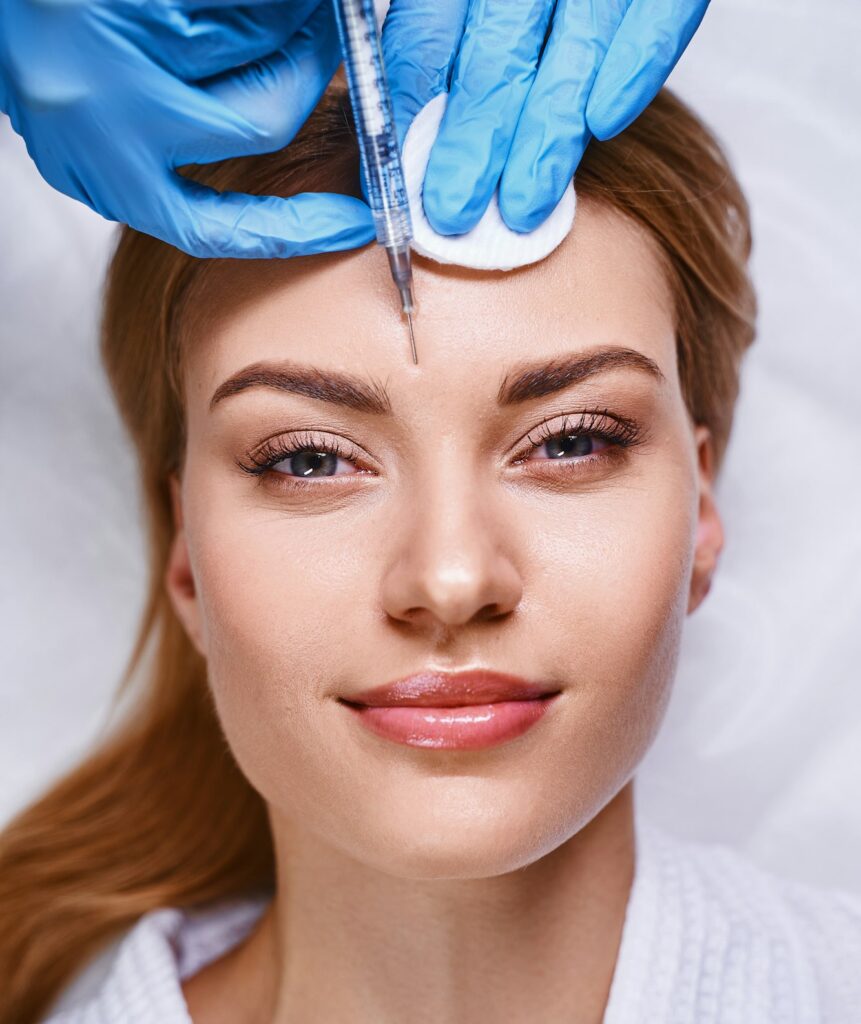 Smiling female getting botox injections stock photo